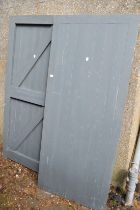 A pair of painted braced and ledged exterior doors.