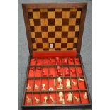 A chess board / storage box containing numerous chess pieces.