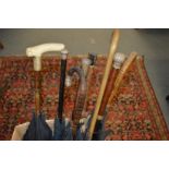 A good collection of parasols, some with silver handles (canopies AF).