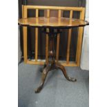 A mahogany tripod table with pie crust top on bird cage movement.