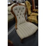 A Victorian walnut framed and button upholstered nursing chair.