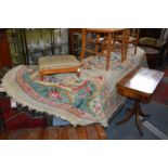 A large cream ground oval floral decorated rug.