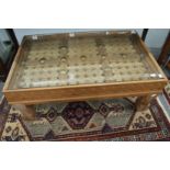 An eastern carved hardwood door converted to a coffee table with glass top.