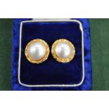 A pair of decorative ear studs with pearl centres, stamped 18ct. Gross weight 12 grams