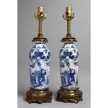 A PAIR OF CHINESE BLUE AND WHITE PORCELAIN LAMPS with ormolu mounts. 19ins high.