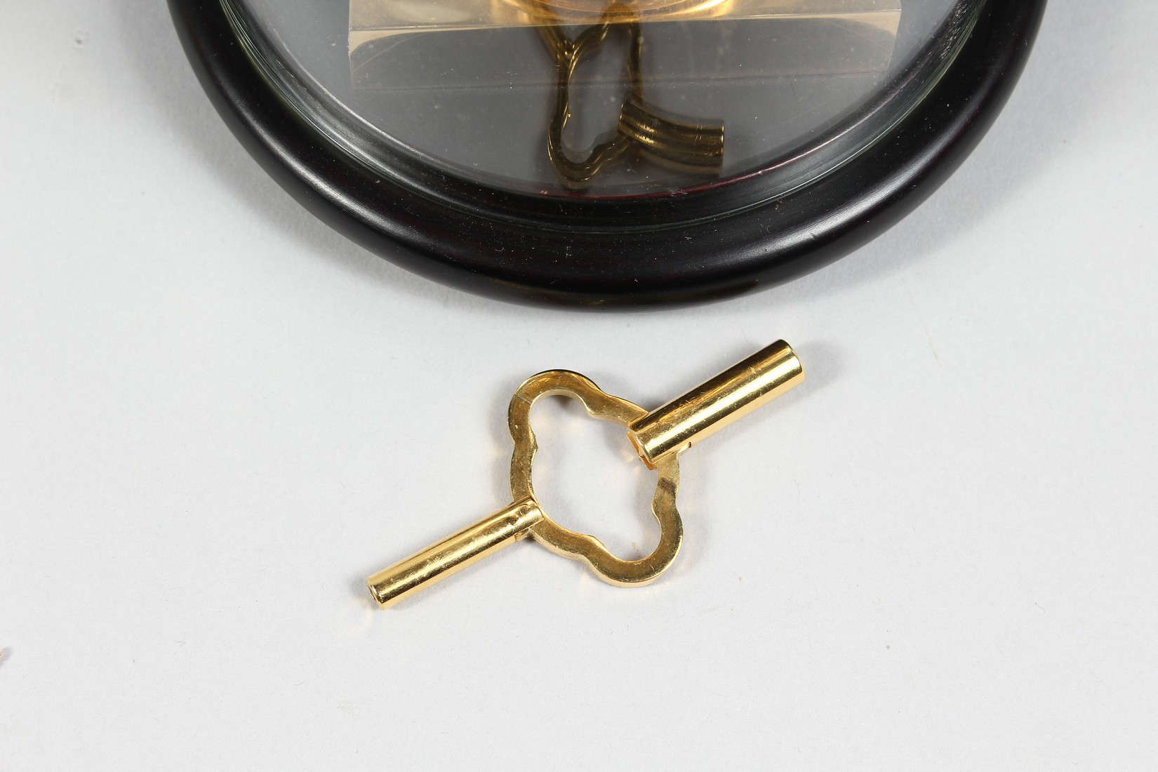 AN UNUSUAL BRASS COLUMN CLOCK with enamel dial, large spring driven movement, under a glass dome. - Image 4 of 4