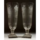 A GOOD PAIR OF CUT GLASS TAPERING VASES on stepped square bases. 17ins high.