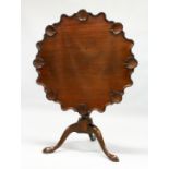 A GEORGE III MAHOGANY "SUPPER TABLE" the shaped circular tilt top with a carved shell shaped