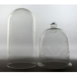 A BELL SHAPED GLASS DOME/COVER with engraved decoration, together with a plain glass dome. 8.5ins