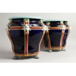 A GOOD PAIR OF MINTON BLUE AND WHITE POTTERY JARDINIERES with mask mounts on claq feet. 12ins
