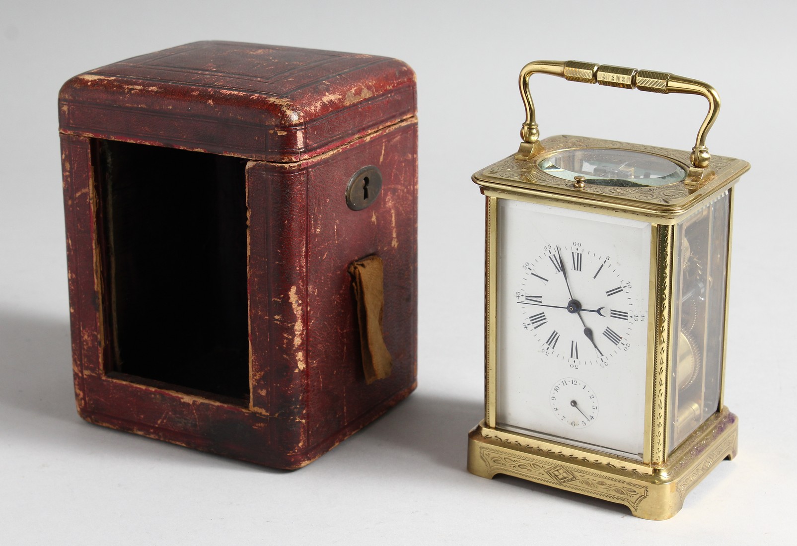 A GOOD FRENCH ENGRAVED BRASS CARRIAGE CLOCK with eight day movement, striking on a gong, enamel dial