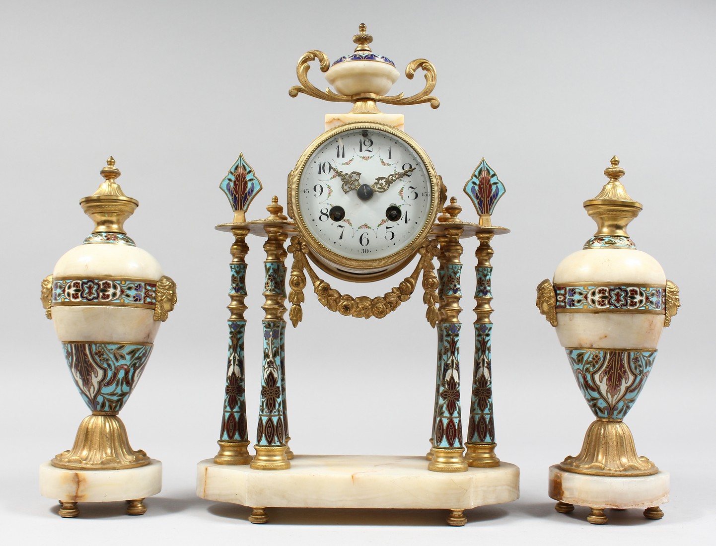 A 19TH CENTURY FRENCH MARBLE ORMOLU AND CHAMPLEVE ENAMEL CLOCK GARNITURE, the clock with eight day