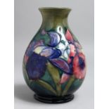 A MOORCROFT BULBOUS VASE, various flowers with Moorcroft signature and label. 7.5ins high.