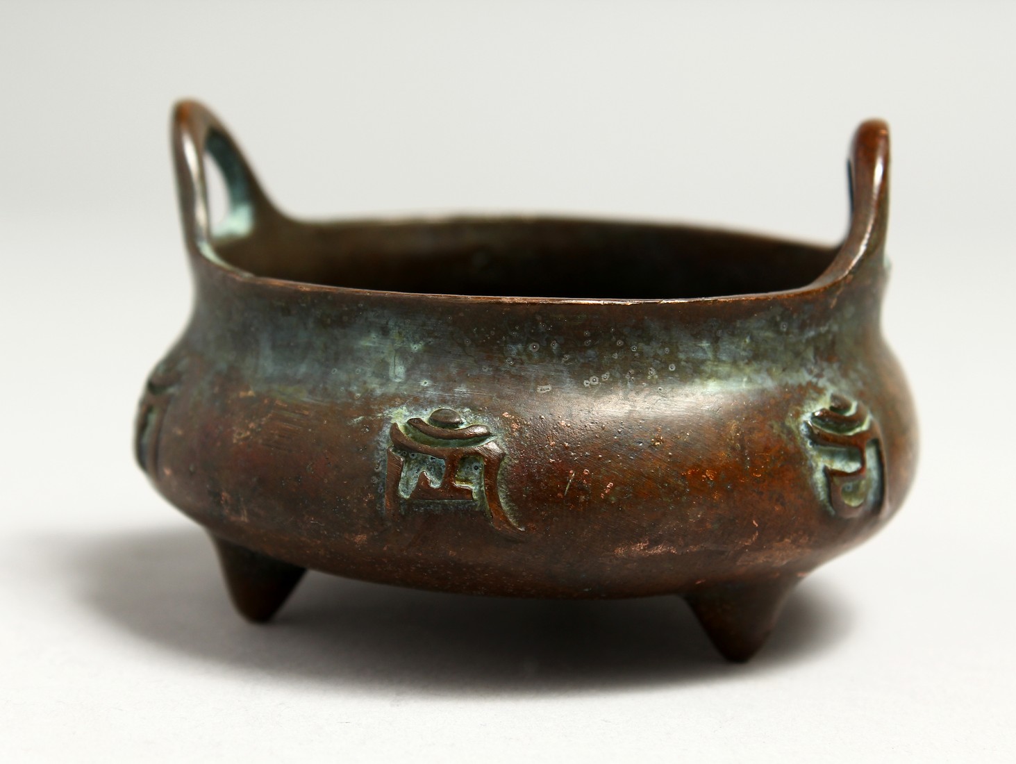 A SMALL CHINESE BRONZE CIRCULAR CENSER, the side with caligraphy. 8cm diameter.