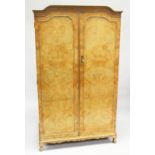 HARRODS LTD. A BLONDE WOOD TWO DOOR WARDROBE with shaped cornice, fitted interior on cabriole