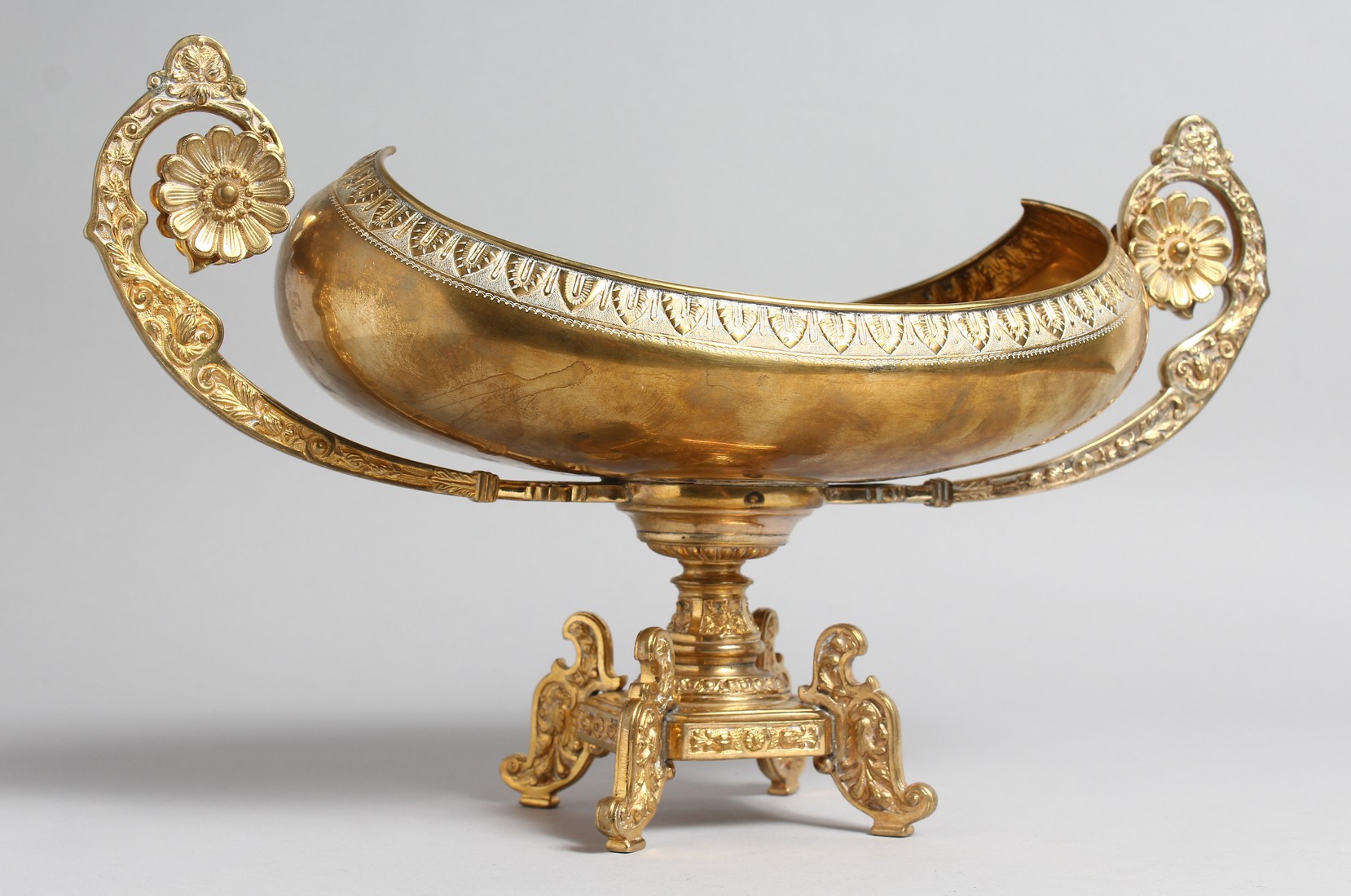 A DECORATIVE CLASSICAL STYLE GILT BRONZE TWIN HANDLED PEDESTAL OVAL SHAPE BOWL. 15.5ins high.