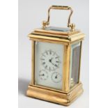 A MINIATURE BRASS CARRIAGE CLOCK with three dials, 3ins high.