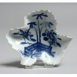 AN 18TH CENTURY BOW EARLY LEAF SHAPED PICKLE DISH painted with a fence and bamboo trees, workman's