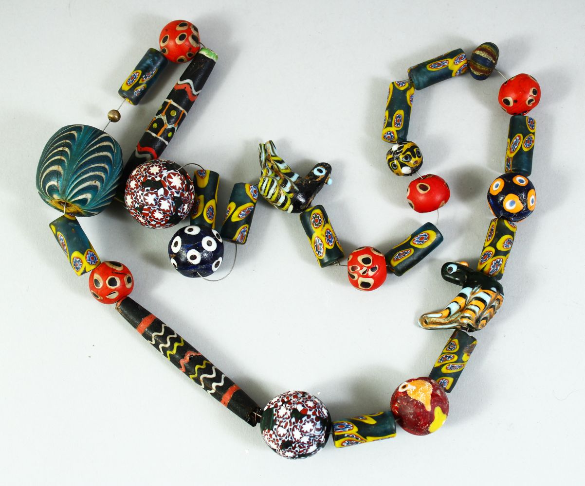 AN ISLAMIC GLASS BEADED NECKLACE, of different styles and sizes including two marvered glass