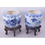 A PAIR OF JAPANESE BLUE AND WHITE PORCELAIN HIBACHIS on hardwood footed stands, each decorated