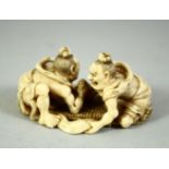 A SMALL JAPANESE CARVED IVORY OKIMONO, depicting two male figures arm wrestling, signed to base, 5.