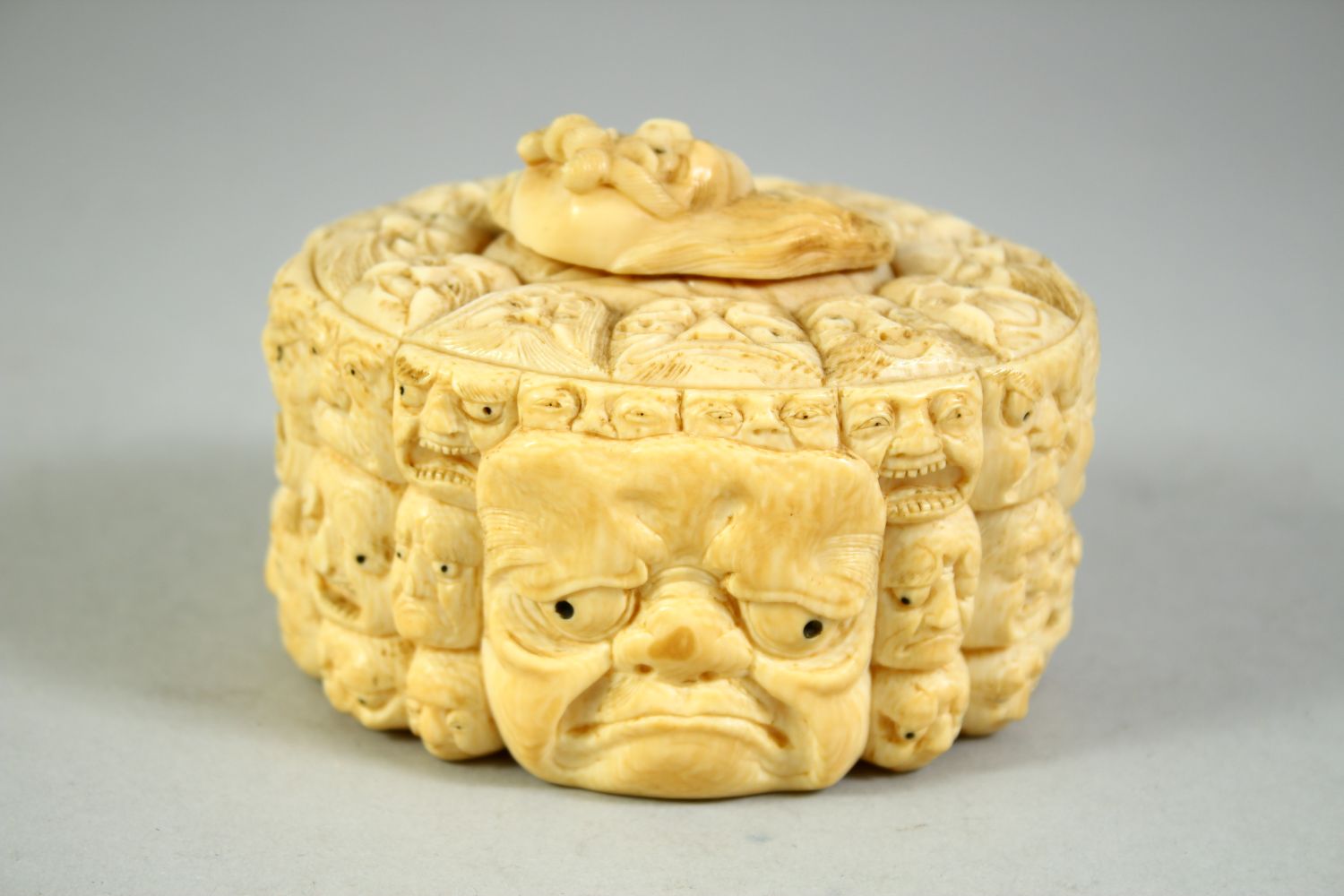 A JAPANESE CARVED IVORY NOH MASK BOX AND COVER, the box carved all over with various theatre masks - Image 3 of 8