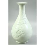 A CHINESE CELADON GLAZE DRAGON VASE, the body with carved dragon and stylised clouds, 30cm high.