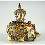 AN INDIAN CARVED IVORY ELEPHANT FIGURE, caparisoned with gilt metalwork inset with a variety of