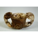 A CHINESE CUT GLASS TWIN HANDLE LIBATION CUP, 10cm wide.