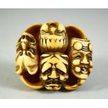 A JAPANESE CARVED IVORY NETSUKE, carved as a roundel of noh masks, discreetly signed inside, 4cm.