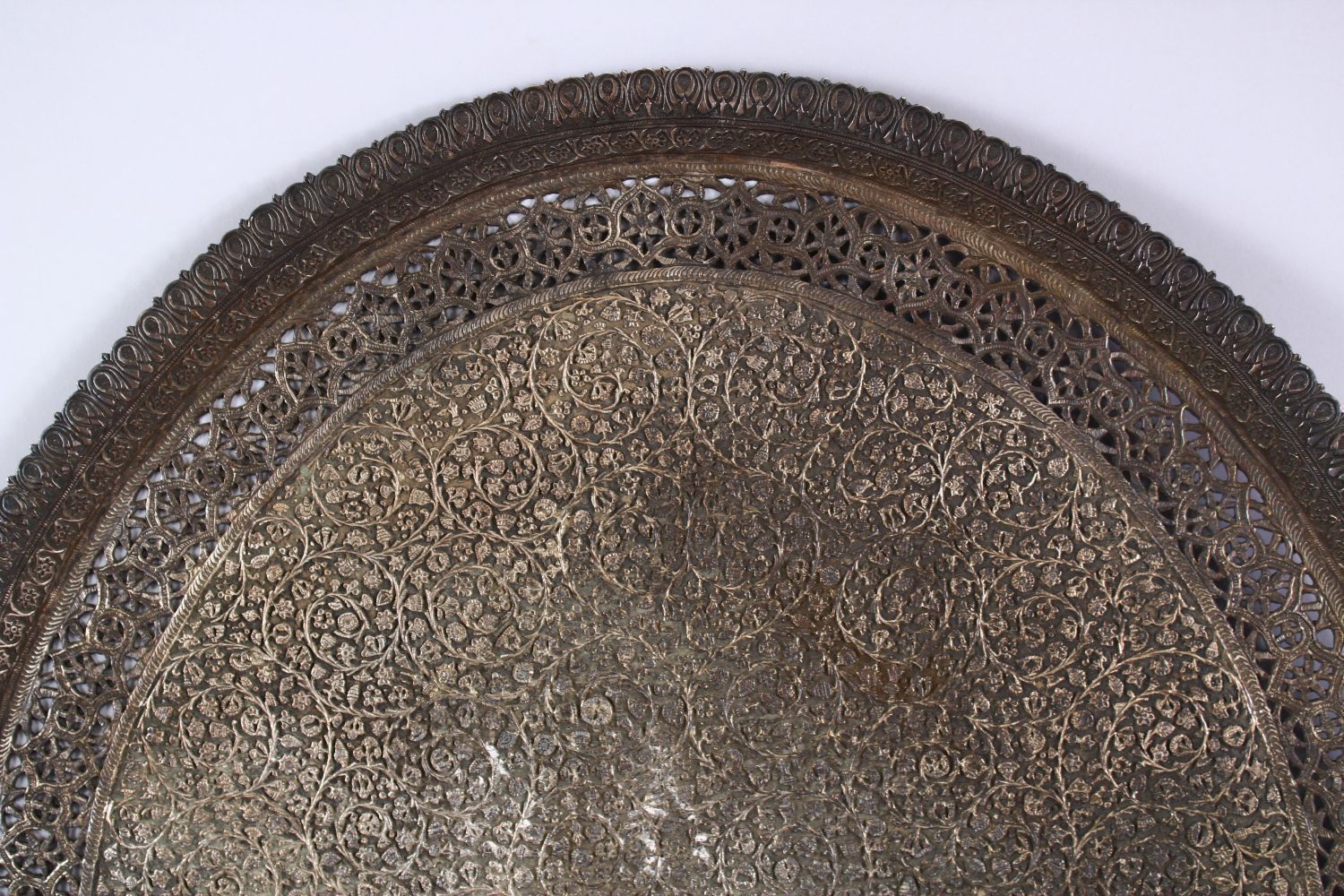 A LARGE INDIAN SILVERED BRONZE OR BRASS TRAY, with a central crest and scrolling foliate, 68.5cm x - Image 2 of 6