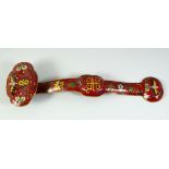 A CHINESE CLOISONNE RUYI SCEPTRE, red ground, decorated with bats and flowers. 1ft 4ins long.