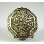 AN ISLAMIC WHITE METAL OCTAGONAL QURAN AMULET BOX, possibly silver, 7.5cm diameter.