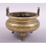 A CHINESE BRONZE TWIN HANDLE TRIPOD CENSER, with engraved and chased decoration, the base with six-