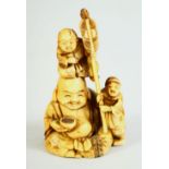A JAPANESE CARVED IVORY NETSUKE, depicting buddha with children, signed to base, 6cm high.