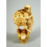 A JAPANESE CARVED IVORY NETSUKE, of a standing male figure with a drum upon his back, a figure