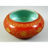 A CHINESE RED GROUND PORCELAIN BOWL, with raised gilt decoration, the interior and base with
