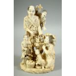 A JAPANESE MEIJI PERIOD CARVED IVORY OKIMONO GROUP, depicting a family with baskets of various