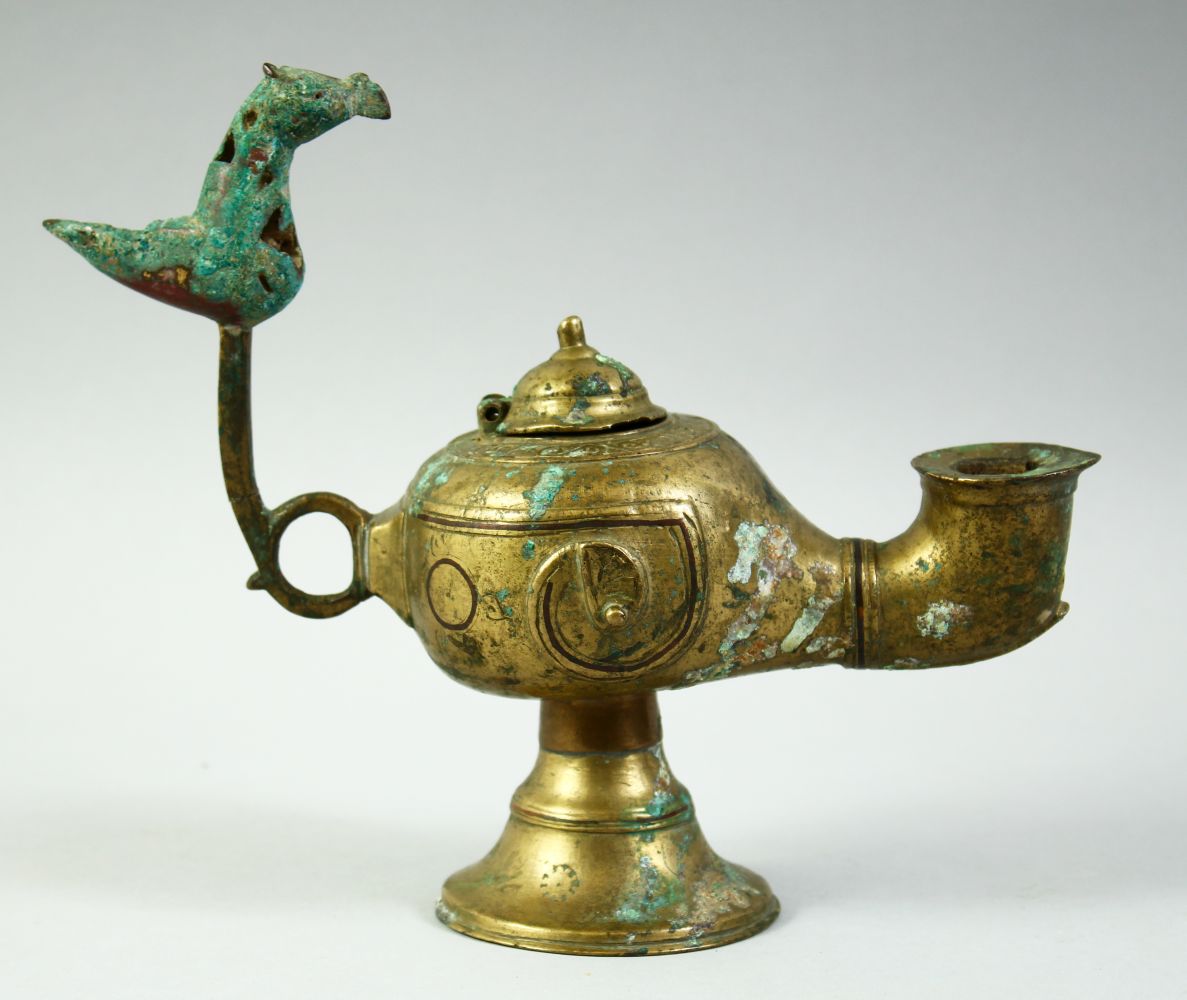 AN ISLAMIC GILT BRONZE OIL LAMP, with lid and zoomorphic finial, 20cm long.