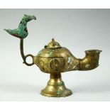 AN ISLAMIC GILT BRONZE OIL LAMP, with lid and zoomorphic finial, 20cm long.