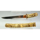 A JAPANESE CARVED IVORY TANTO DAGGER, the scabbard and handle finely carved with village scenes