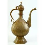 AN ISLAMIC ENGRAVED BRASS EWER, with hinged lid, engraved with floral decoration, 39cm high.