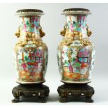 A GOOD PAIR OF CHINESE CANTON PORCELAIN VASES mounted to brass stands, the body of each painted with