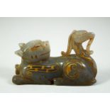 A CHINESE CARVED HARDSTONE FIGURE of a reclining beast, with painted gilt highlights, 7cm long.