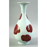 A CHINESE UNDER GLAZED RED AND WHITE DRAGON VASE, the body carved with a dragon and stylised flames,