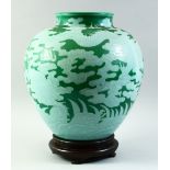 A VERY LARGE UNUSUAL CHINESE GREEN GROUND DRAGON VASE and hardwood stand, decorated with a dragon