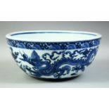 A LARGE CHINESE BLUE AND WHITE PORCELAIN BOWL, decorated with dragons amongst stylised clouds, the