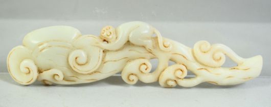 A CHINESE CARVED JADE MODEL OF A MONKEY UPON A RUYI FORMED BRANCH, 15cm long.