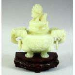 A CHINESE CARVED JADE LIDDED KORO ON A HARDWOOD STAND, with twin ring handles carved as temple