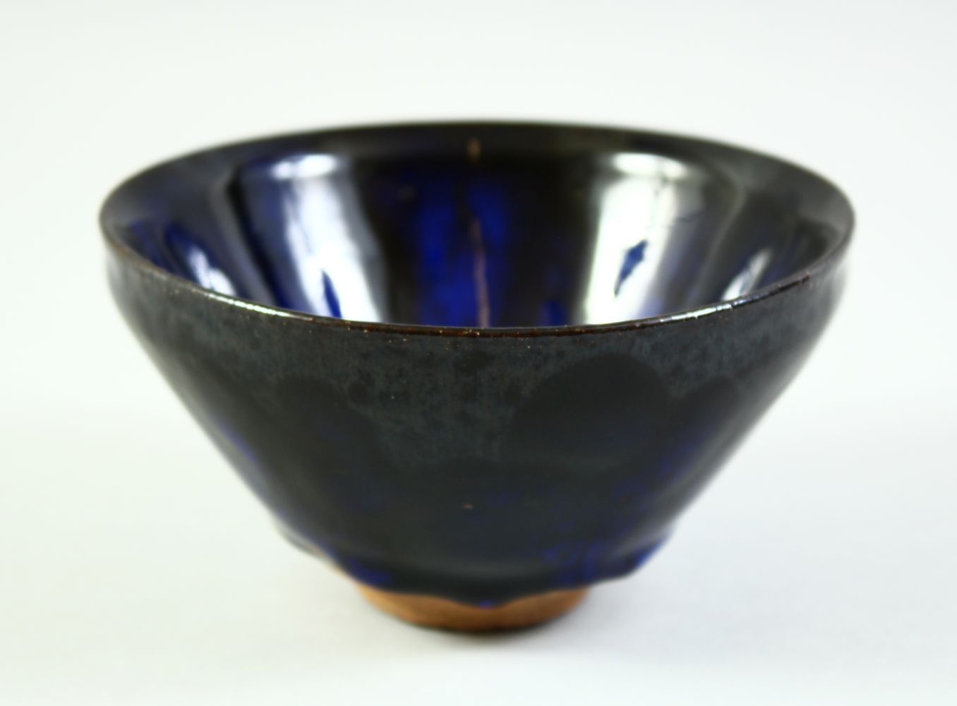 A CHINESE DARK BLUE GLAZE POTTERY BOWL, with carved mark to base, 12cm diameter.